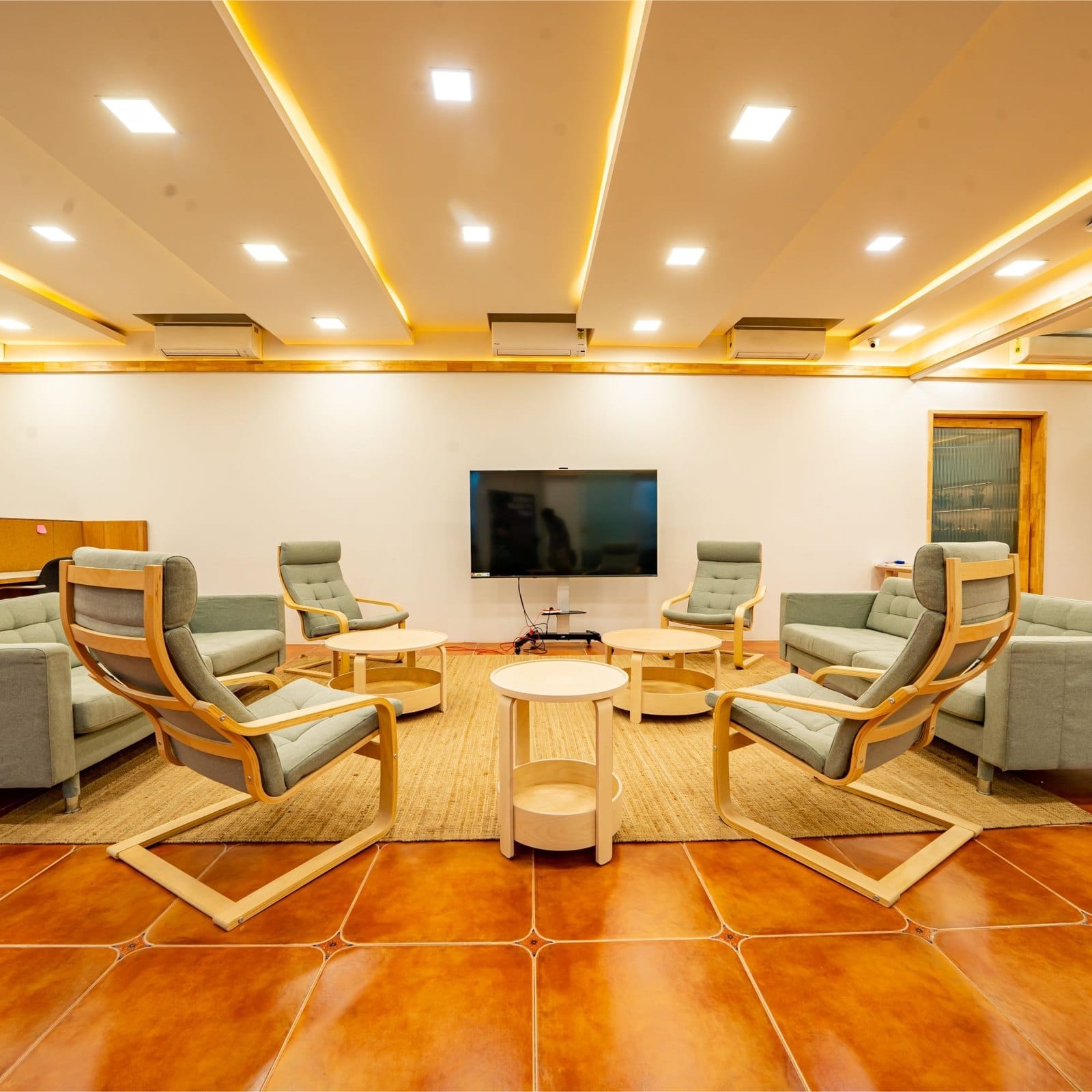 Lounge seating: armchairs around low tables, facing a screen